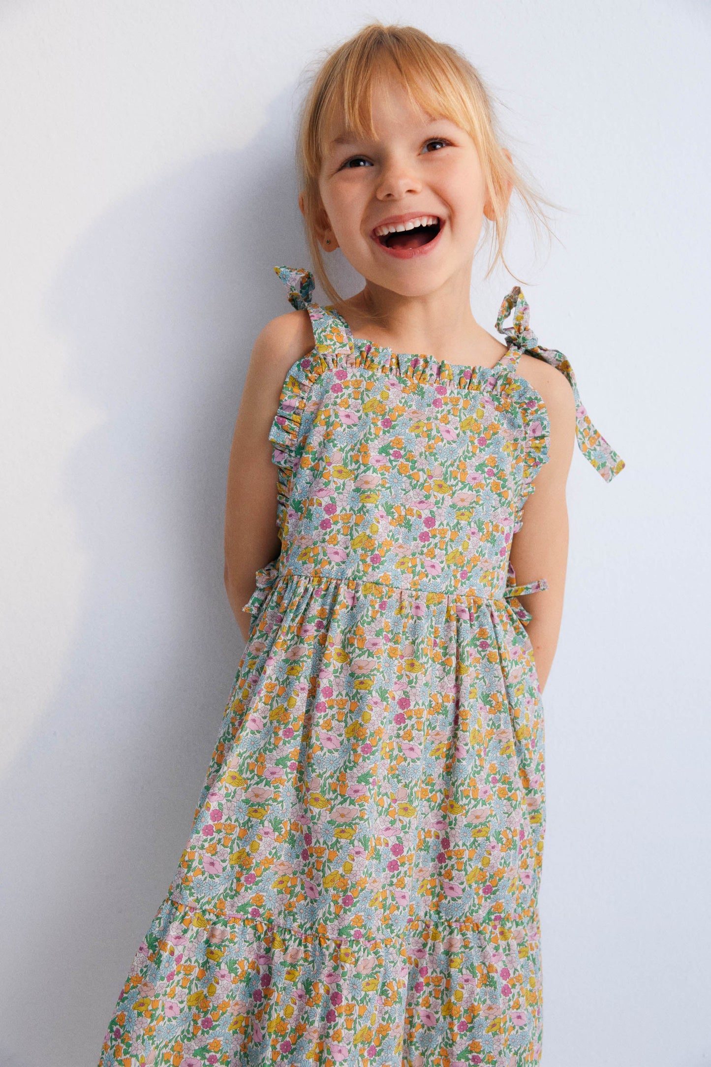 Andreas Dress in Liberty fabric, with front ruffles and a cut to create volume in the ruffle, with bow details on the sides and shoulder straps. Spring Summer Collection. The New Scoiety.
