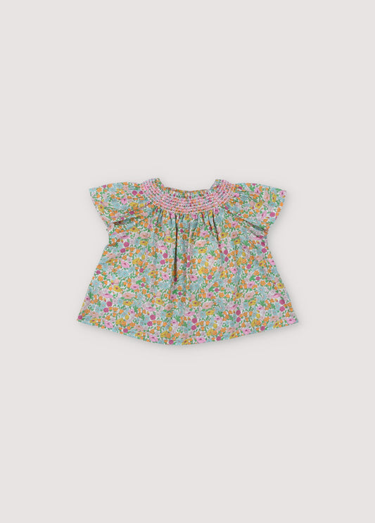 Andreas Baby Blouse in Liberty fabric, short-sleeved raglan, smoke with hibiscus-colored thread that generates volume throughout the garment. Spring Summer Collecton. The New Society.