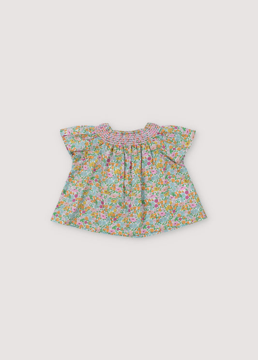 Andreas Baby Blouse in Liberty fabric, short-sleeved raglan, smoke with hibiscus-colored thread that generates volume throughout the garment. Spring Summer Collecton. The New Society.