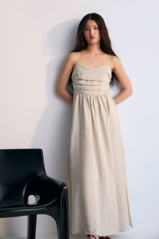 Anna Woman Dress in 100% linen fabric, with spaghetti straps, pleated panel on the top, and a long skirt with volume. Spring Summer collection. The New Society. 