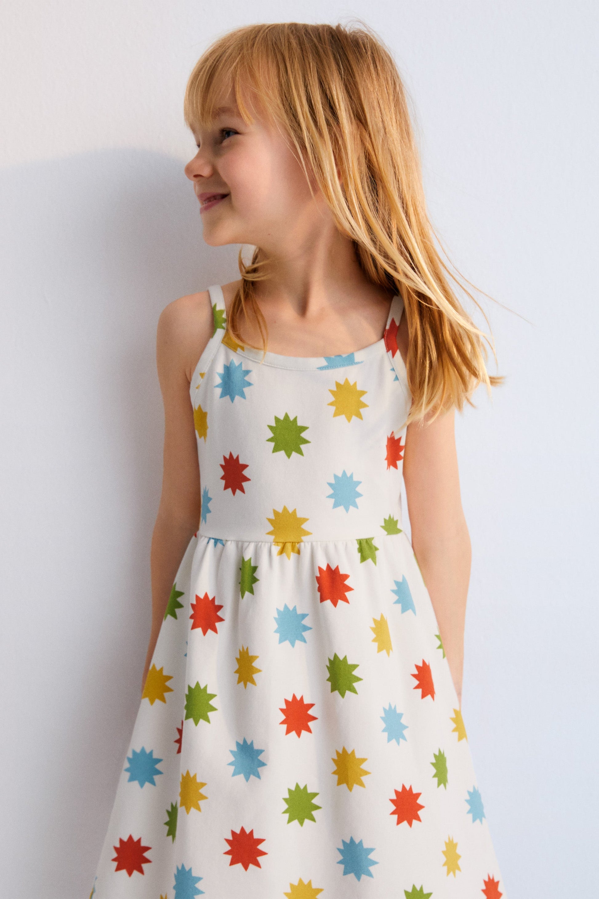
Short jersey dress with multicolored star print, spaghetti straps, and gathered waist. New Collection. Spring Summer. The New Society.