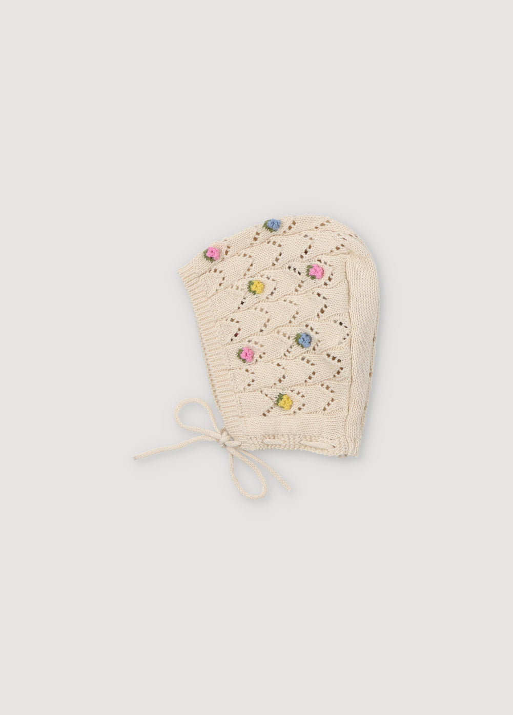 Knit baby hat with structure and flower details. It has two ties of the same yarn to tie. Spring Summer Collection. The New Society.
