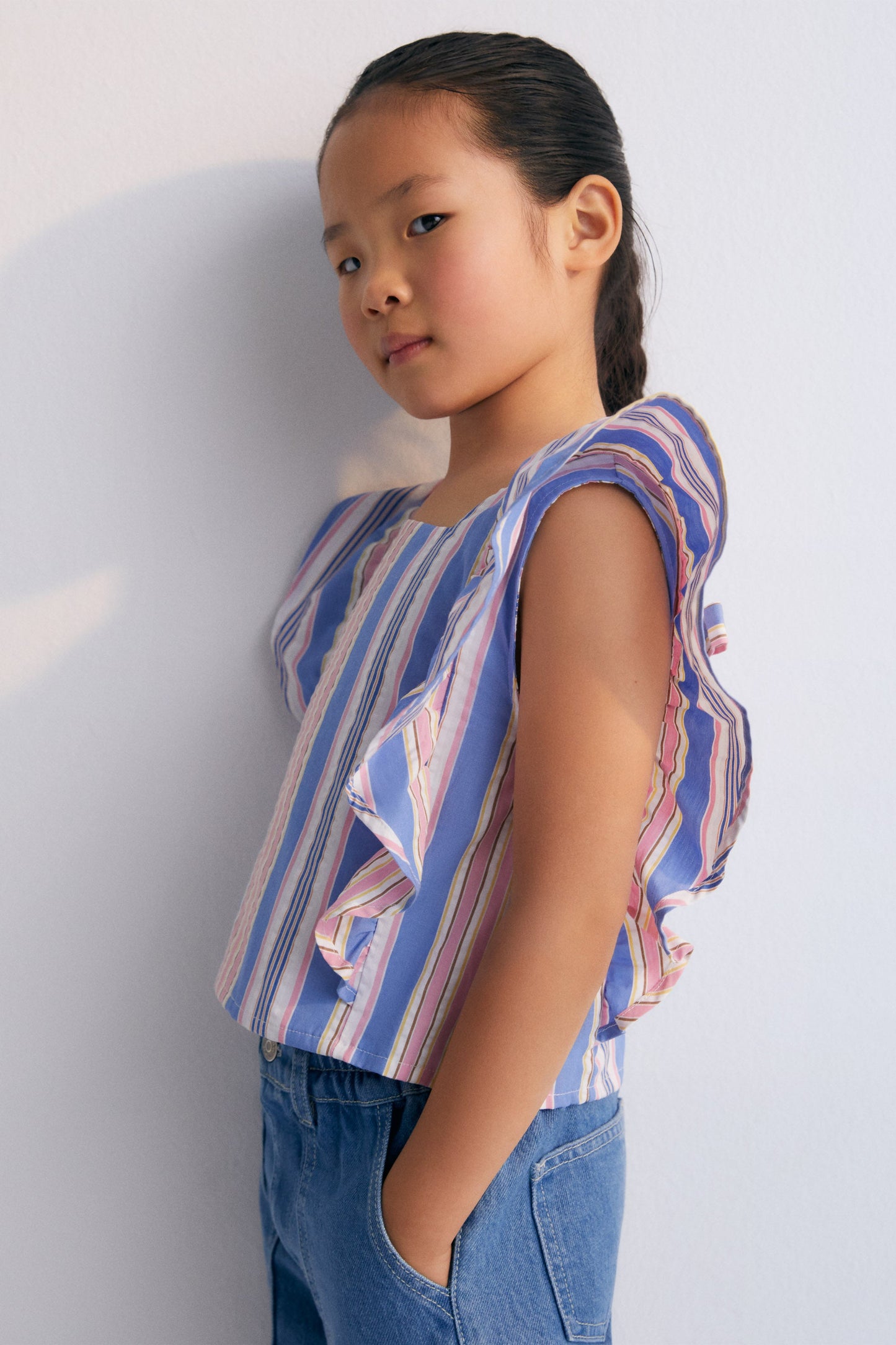 Chara Blouse in 100% cotton striped fabric, with ruffles on the sides and adjustable back with a tie.