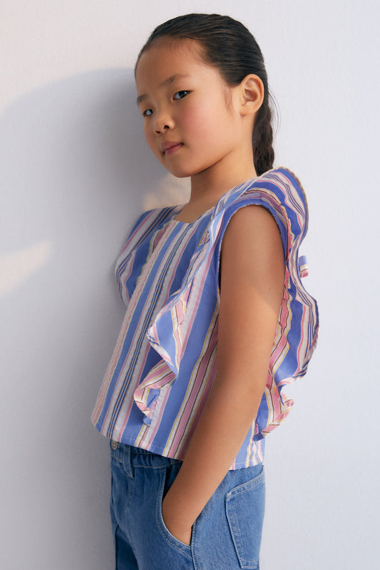 Chara Blouse in 100% cotton striped fabric, with ruffles on the sides and adjustable back with a tie.