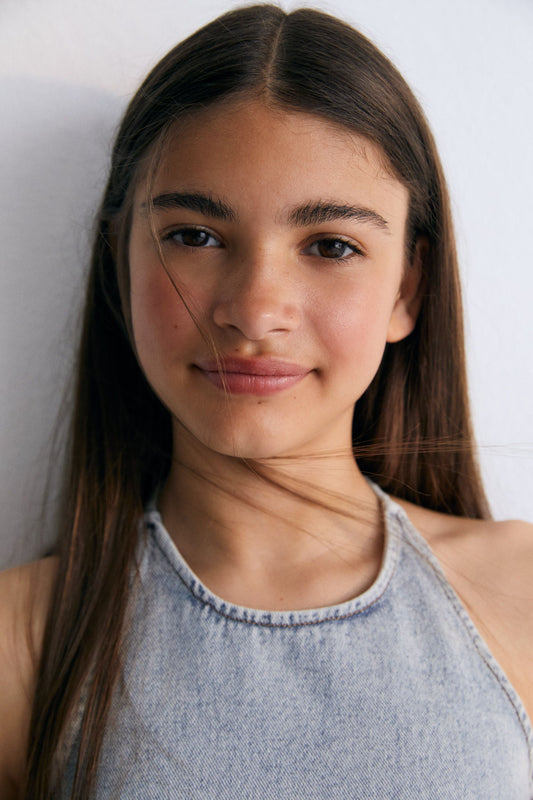 Chios Teen Top in denim fabric 100% cotton, halter neck top with bust darts and a fitted waist, with a side zipper. Spring Summer Collection. The New Society.