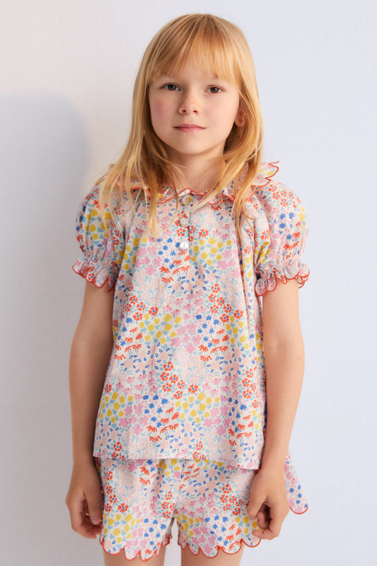 Greneva Blouse in 100% cotton voile with our anemone print. Short-sleeved blouse with a ruffle, gathered neckline with embroidery, and open neckline with button closure. Kids Collection. The New Society